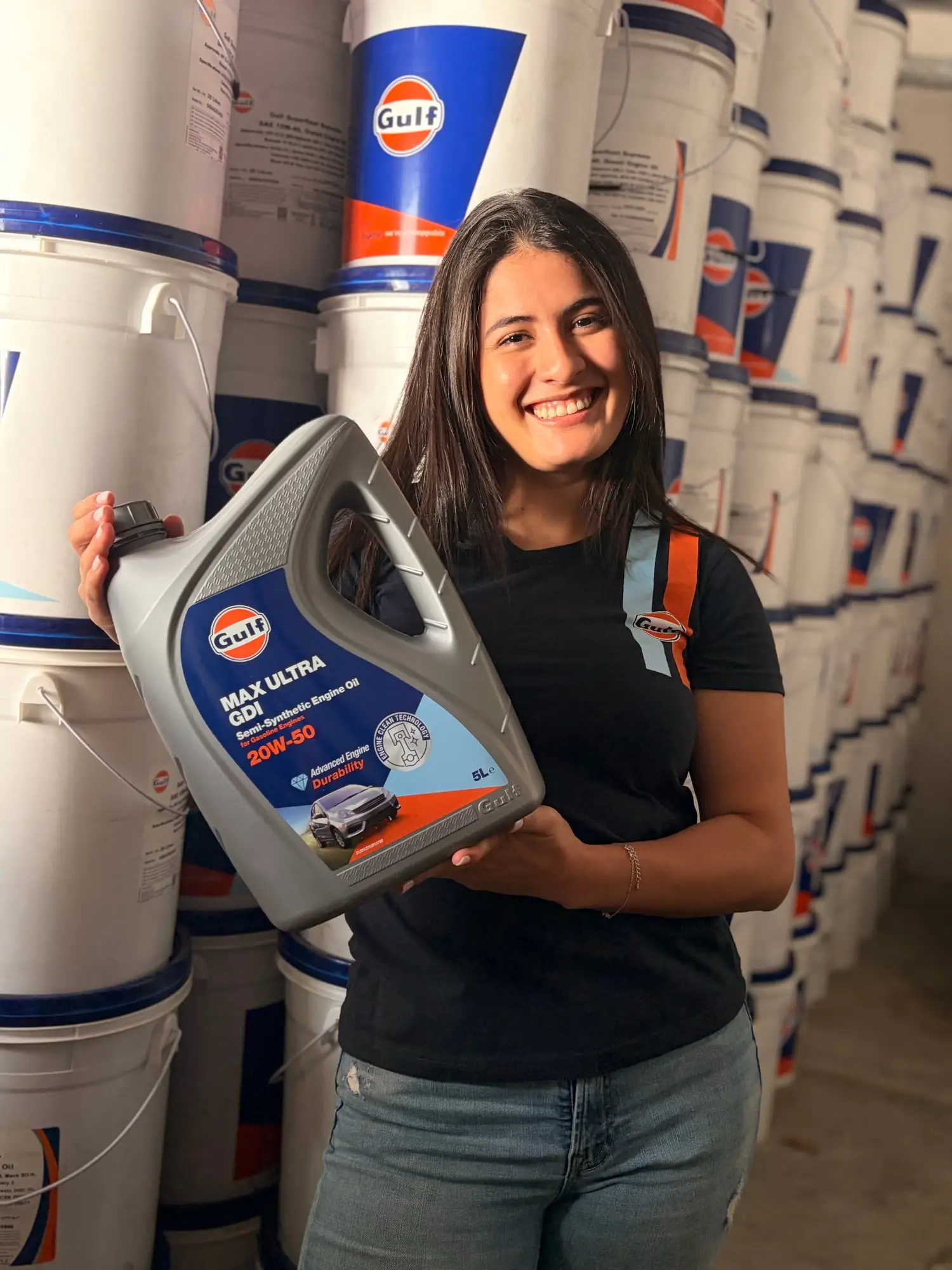 Asesora de CR Autos con un envase de aceite Gulf Max Ultra en la bodega de producto Gulf